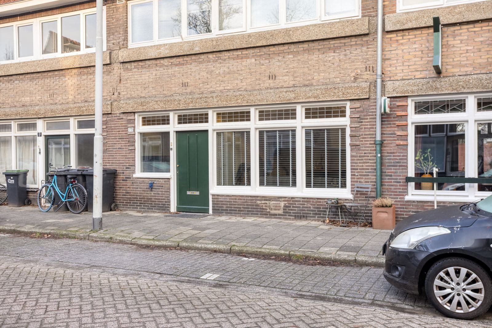 Entree met groene voordeur en brede raampartij